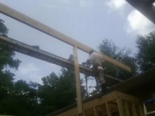 Carpenter setting a ridge beam over a new addition frame — Ice Dam Removal by Roofing Brothers in Viewtown
