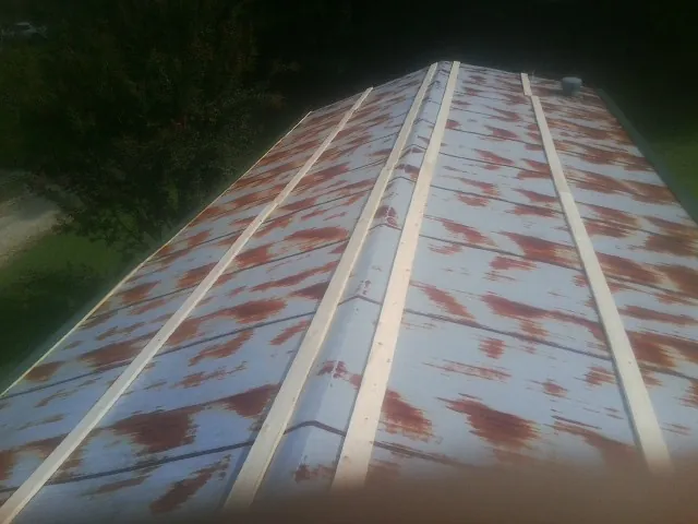 Rusted metal roof panels with new wood purlins before replacement — Storm Damage Roof Repair in Viewtown by Roofing Brothers