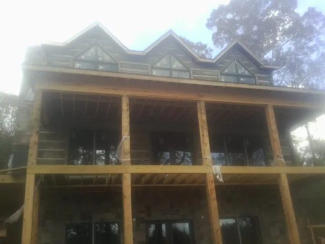 Dormers and porch framing on a large log home under construction — Roof Coating work by our crew in Viewtown