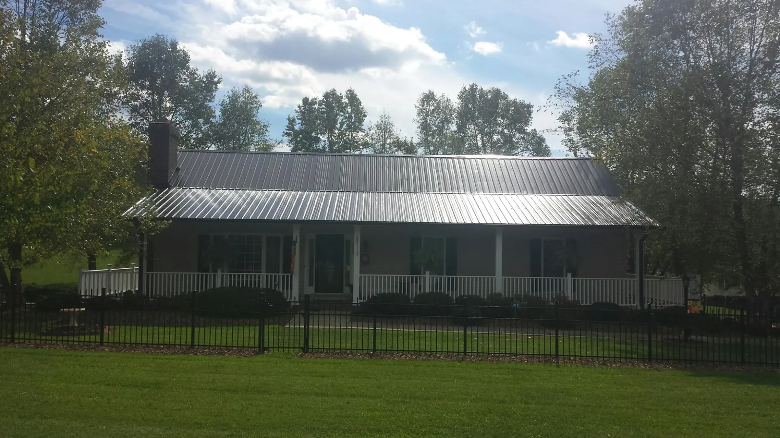 Gray metal roof on a brick ranch with a full width front porch — Gutter Guard Installation work by our crew in Viewtown