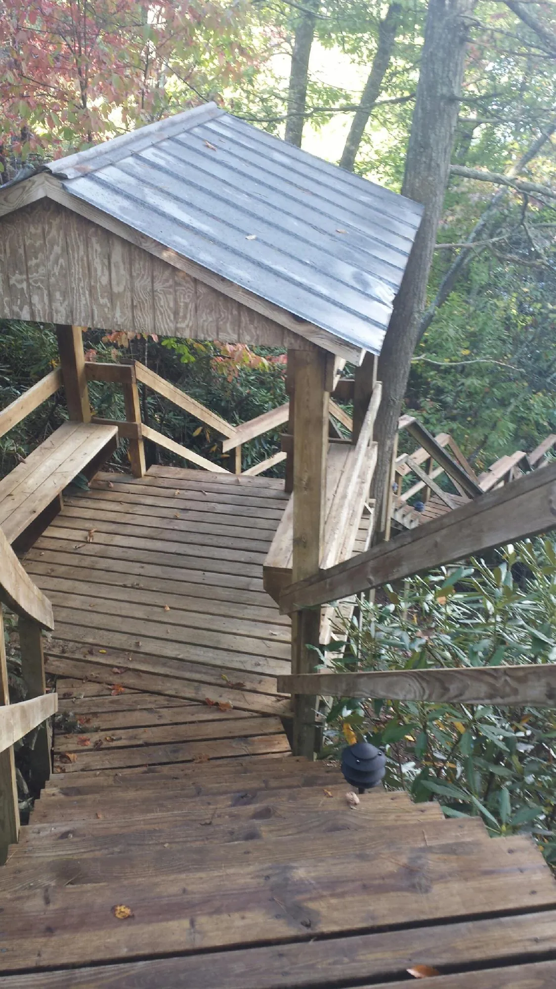 Metal roofed shelter over wooden steps on a wooded walkway — Skylight Repair & Installation work by our crew in Viewtown