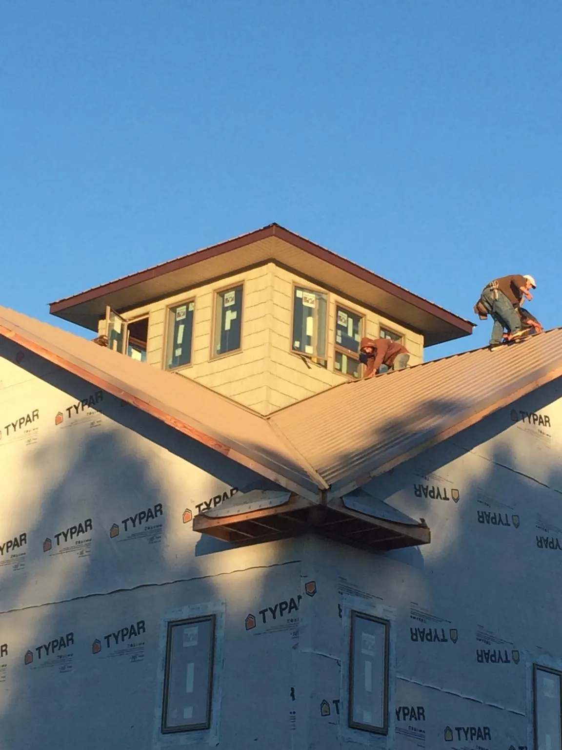 Roofers working around a rooftop cupola on a new metal roof at sunset — Roof Waterproofing in Viewtown by Roofing Brothers